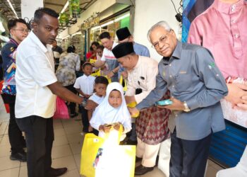 A. SIVANESAN menyampaikan sumbangan pakaian raya kepada pelajar sekolah di Bidor.