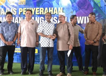 ZAMBRY Abd Kadir (tiga dari kiri) menyampaikan bantuan kepada penerima pada Majlis Penyerahan Bantuan Wang Ihsan (BWI) Daerah Manjung di Lumut hari ini. - UTUSAN/ZULFACHRI ZULKIFLI