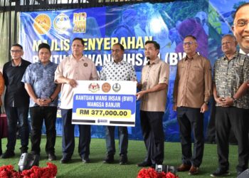 ZAMBRY Abd Kadir (tengah) menyaksikan penyerahan replika cek antara Agensi Pengurusan Bencana (NADMA) dengan Pegawai Daerah Manjung pada Majlis Penyerahan Bantuan Wang Ihsan (BWI) Daerah Manjung di Lumut hari ini. - UTUSAN/ZULFACHRI ZULKIFLI