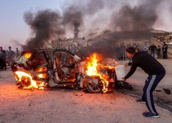 SEORANG lelaki cuba memadamkan kebakaran melibatkan kereta milik wartawan Palestin, Mohammed Washeha yang terkorban akibat serangan udara Israel di selatan Gaza City. - AFP