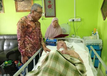 WAN Ahmad Dahlan Abdul Aziz (kiri) menziarah Md. Suli Daud yang terbaring dan terlantar di rumahnya di Taman Ria, Sri Lalang, Kluang.