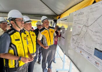 AKMAL Nasrullah Mohd. Nasir (kiri) dan Aminuddin diberi penerangan mengenai projek Jalan Baharu dari Nilai-Labu ke Bandar Enstek, Seremban di Nilai, Seremban hari ini. -UTUSAN/ NOR SHAFIQAH MOHD. GHAZALI