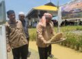 TUAN Mohd. Saripudin Tuan Ismail (kanan) menunjukkan kebolehan menampi padi selepas menyempurnakan Majlis Perasmian Penutup Bengkel Koperasi Pertanian Al-Falah di Desa Gemalai Baruh Padi Alami, Lubok Jambu, Kota Bharu, Kelantan hari ini. - UTUSAN/MUSTAQIM MOHAMED
