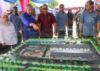 AHMAD Zahid Hamidi melihat replika Projek Pembangunan Industri - PERDA Halal Park (Fasa 2) pada majlis pecah tanah projek itu di Kubang Menerong, Tasek Gelugor, Pulau Pinang.- UTUSAN/DANIAL SAAD