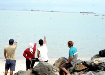 BEBERAPA penduduk kampung menunggu ketibaan kapal tangki Ocean Thunder yang membawa minyak mentah selepas melepasi Selat Hormuz yang berdepan konflik Asia Barat di perairan Pantai Sungai Rengit, Pengerang Kota Tinggi disini. - UTUSAN/RAJA JAAFAR ALI