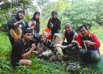 HALIJAH Shahari (duduk, tengah) menunjukkan hasil tangkapan bersama keluarganya ketika ditemui di Sungai Muar di Kampung Sawah Lebar di Kuala Pilah, hari ini.- UTUSAN / NOR SHAFIQAH MOHD GHAZALI