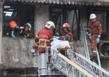 BEBERAPA anggota bomba sedang menurunkan mayat salah seorang daripada mangsa yang maut dalam kebakaran di sebuah rumah kedai dua tingkat yang dijadikan pejabat guaman di Jalan Lebuh King, George Town, Pulau Pinang hari ini. - UTUSAN/DANIAL SAAD