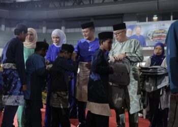 Mohd. Hairi Mad Shah (tengah) menyampaikan sumbangan kepada penerima pada majlis Raya Sekampung Bangsa Johor DUN Larkin di Arena Larkin, Johor Bahru hari ini