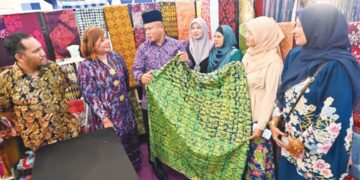 JUHARI Azmi (tiga, kiri) melihat produk batik yang dijual di Festival Kraf Pantai Timur 2026 di East Coast Mall di Kuantan, Pahang.– MINGGUAN/SHAIKH AHMAD RAZIF