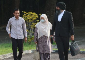 FAHMI Zainol (kiri) ditemani isterinya, Nur Hidayah Abd. Jabar (tengah) dan peguamnya, Dr. Shamsher Singh Thind ketika hadir di Mahkamah Majistret Balik Pulau, Pulau Pinang hari ini.-UTUSAN/DANIAL SAAD