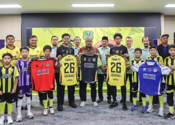 Mohd Firdaus (Tengah) menunjukkan jersi yang akan dipakai pasukan PBMM dalam dalam saingan Liga Remaja Kebangsaan Program Pembangunan Bolasepak Negara (NFDP) 2026.