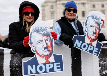 PENUNJUK perasaan memegang papan tanda yang memaparkan imej Presiden Donald Trump semasa protes kebangsaan di Minnesota pada 28 Mac lalu.- AFP