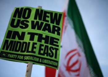 PENUNJUK perasaan memegang papan tanda dan bendera ketik berhimpun berhampiran Rumah Putih untuk membantah perang ke atas Iran di Washington, DC.- AFP