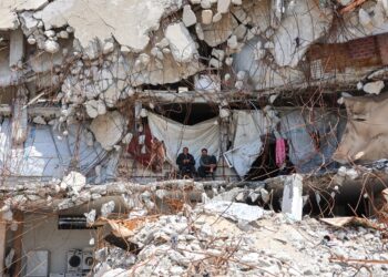 PELARIAN Palestin duduk di celah runtuhan bangunan yang dijadikan kem perlindungan sementara di Jabalia, utara Gaza.- AFP