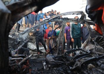 WARGA Palestin memeriksa sebuah kenderaan yang menjadi sasaran serangan Israel di kem pelarian Maghazi di tengah Gaza.-AFP