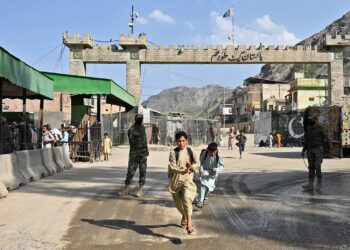 ANGGOTA keselamatan Pakistan berkawal ketika budak lelaki Afghanistan berlari di Lintasan Sempadan Antarabangsa Torkham antara Afghanistan dan Pakistan, wilayah Nangarhar.- AFP