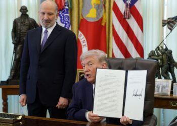 DONALD Trump memegang perintah eksekutif untuk mengehadkan undian melalui pos di Pejabat Oval, Rumah Putih di Washington, DC, kelmarin.- AFP