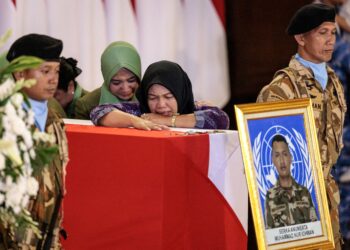 AHLI keluarga Muhammad Nur Ichawan bersedih ekoran pemergiannya ketika tiga keranda anggota pengaman tentera Indonesia tiba di LapanganTerbang Antarabangsa Soekarno-Hatta,  Tangerang.- AFP