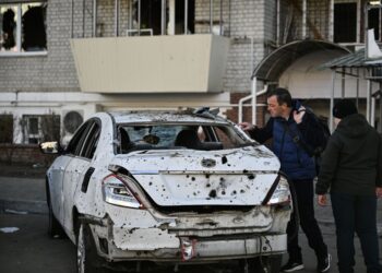 PENDUDUK melihat sebuah kereta yang rosak akibat serangan dron Russia di hadapan sebuah bangunan kediaman di bandar Brovary, berhampiran Kyiv. - AFP