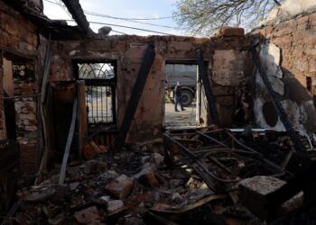 SEORANG penduduk tempatan berjalan melepasi sebuah rumah yang musnah akibat serangan udara di Odesa, Ukraine.- AFP