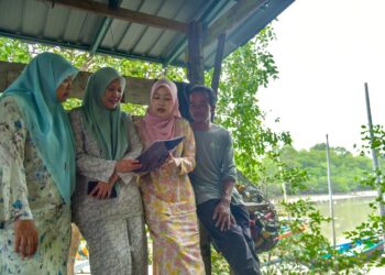 MARZITA Mansor (kiri) melihat keputusan cemerlang 9A yang diperoleh Nur Diana Zahirah Yusni,18, (dua dari kanan) dalam SPM di
jeti nelayan, Kampung Sanglang, Arau, Perlis hari ini.-UTUSAN/IZLIZAN OTHMAN