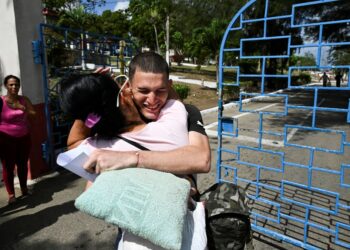 SEORANG banduan (kanan) memeluk ahlu keluarga selepas dibebaskan dari penjara La Lima di Havana kelmarin.- AFP
