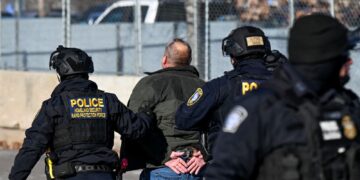 PEGAWAI polis Jabatan Keselamatan Dalam Negeri (DHS) menahan seorang lelaki di luar Bangunan Persekutuan Bishop Henry Whipple di Minneapolis, Minnesota.- AFP