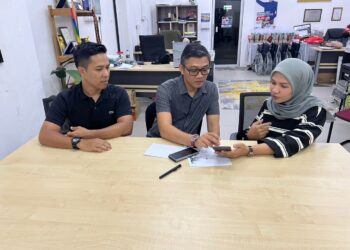 Siti Nur Ain Abd Sanief (kanan) menunjukkan keadaan ibunya kepada Izizam Ibrahim  di pejabat DUN Titi Tinggi, Padang Besar, Perlis semalam. -UTUSAN/ASYRAF MUHAMMAD