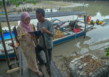 NUR Diana Zahirah Yusni,18, menunjukkan keputusan semua 9A SPM kepada bapanya di Kampung Sanglang, Arau, Perlis semalam.-UTUSAN/IZLIZAN OTHMAN