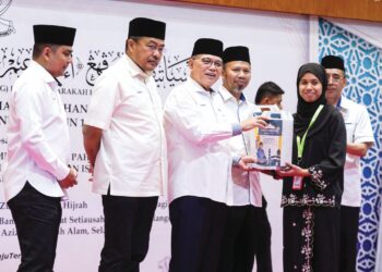 WAN Rosdy Wan Ismail menyampaikan Inisiatif Makmur Pahang (I.M Pahang) kepada pekerja swasta, Alya Sorfina Ahmad, 24, pada Majlis Perasmian Kursus Perdana Haji dan
Penyampaian Inisiatif Makmur Pahang Program Barakah Haji (Perantau) Tahun 1447 Hijrah/2026 Masihi di Bangunan Sultan Salahuddin Abdul Aziz Shah, Shah Alam, semalam.
– UTUSAN/AFIQ RAZALI
