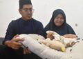 AISYAWATI Isa dan Mohamad Zaerwafar Che Mat Zaidin tidak dapat menahan sebak ketika menunjukkan barangan bayi mereka yang meninggal dunia ketika di bawah jagaan pengasuh di Taman Sri Wang Fasa 1, Arau, Perlis semalam. -UTUSAN/ASYRAF MUHAMMAD