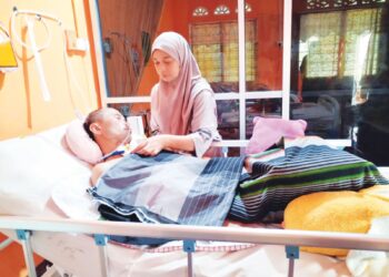 NOORSHASILA Yusof menjaga Khairul Azmi Abdul Rahman yang terlantar di Felda Sungai Tekam Utara di Jerantut, Pahang. 
– UTUSAN/HARIS FADILAH AHMAD