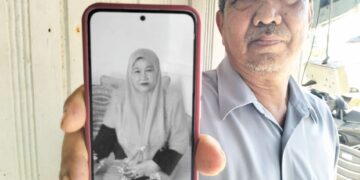 MAZELAN Daud menunjukkan gambar isterinya, Sha’adah Muhammad yang maut akibat melecur selepas rumah mereka di Kampung Simpangan, Pengkalan Kubor, Tumpat, Kelantan terbakar bulan lalu. 
– UTUSAN/ROHANA ISMAIL