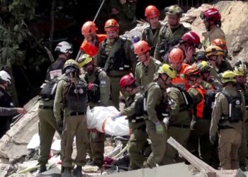 PASUKAN penyelamat Israel mengeluarkan mayat dari bawah runtuhan sebuah bangunan kediaman yang musnah akibat serangan peluru berpandu Iran di bandar utara Haifa semalam. - AFP