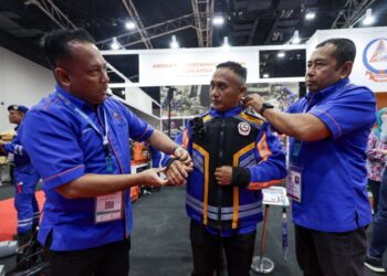 SHAHRIZAL Hussin (kiri) mengenakan jaket pelbagai guna Ai-SU pada Anuar Omaroddin sambil dibantu Muhammad Yusof Abdul Rahim (kanan) ketika tinjauan di reruai sempena Pameran Perkhidmatan Pertahanan Asia (DSA) dan Keselamatan Kebangsaan (NATSEC) Asia 2026 di Pusat Pameran dan Perdagangan Antarabangsa Malaysia (MITEC), Kuala Lumpur, semalam.