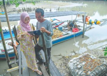 NUR Diana Zahirah Yusni menunjukkan keputusan cemerlang SPM yang diperoleh kepada bapanya di Kampung Sanglang, Arau, Perlis, semalam. – UTUSAN/IZLIZAN OTHMAN.