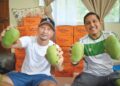 AZMIZI Azmi (kiri) bersama Mohammad Abdul Hamid (kanan) menunjukkan buah Harumanis yang dikutip di kebun mereka di Sungai Batu Pahat, Kangar, Perlis. – UTUSAN/ASYRAF MUHAMMAD