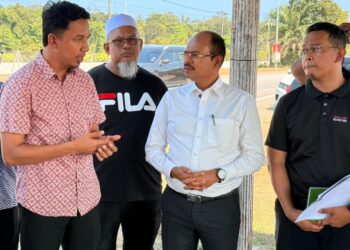 NIK Mohamad Ridzuan Kamaruddin (kiri) menyatakan sesuatu kepada Razali Kassim (tengah) ketika melakukan tinjauan laluan di Sekolah Menengah Kebangsaan Sungai Baging, Indera Mahkota di Kuantan, Pahang.
