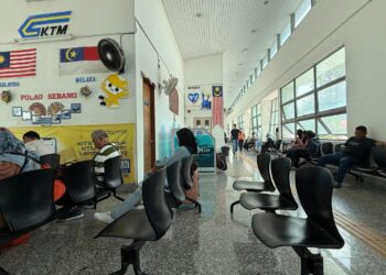 PENUMPANG sedang menunggu ketibaan komuter di Stesen Keretapi Pulau Sebang, Melaka. - UTUSAN/NOR SHAFIQAH MOHD. GHAZALI