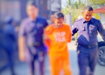 TERTUDUH (tengah) dibawa oleh polis untuk prosiding reman di Mahkamah Majistret Bachok, Kelantan.