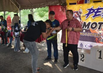 ABU Bakar Hamzah (kanan) menyampaikan pingat kepada pemenang semasa Program Perlis Open Moto x Meeting di Litar Motocross Sungai Batu Pahat, Kangar, Perlis, hari ini. -UTUSAN/ASYRAF MUHAMMAD