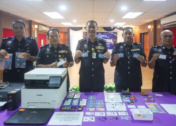 MOHD. Khairi Khairuddin (tengah) menunjukkan kad pengenalan diri palsu yang dirampas dalam sidang akhabr di Ibu pejabat Polis Kontinjen (IPK) Kuala Terengganu, Terengganu. -UTUSAN/PUQTRA HAIRRY