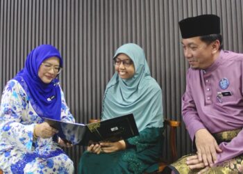 BALQIS Qariirah Mohamad Ashrulnizam (tengah) bersama Khalida (kiri) dan Mohamad Zaini di SMK Dato’ Klana Putra di Lenggeng, Seremban, semalam.- UTUSAN/ NOR SHAFIQAH MOHD GHAZALI