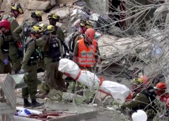 SATU mayat dikeluarkan pasukan penyelamat di Haifa selepas serangan peluru berpandu Iran. - AFP