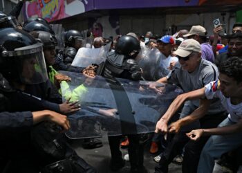 PENUNJUK perasaan bertempur dengan polis di Caracas kelmarin. - AFP