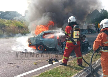 ANGGOTA bomba memadam kebakaran sebuah kereta Proton Saga di Lebuh AMJ, Cheng Heights. FOTO IHSAN JABATAN BOMBA DAN PENYELAMAT MELAKA.