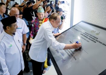 ANWAR Ibrahim menandatangani plak Majlis Perasmian Terminal Baharu Lapangan Terbang Sultan Ismail Petra (LTSIP), Pengkalan Chepa, Kelantan sambil diiringi Mohd. Nassuruddin Daud (kiri), semalam. - MINGGUAN/KAMARUL BISMI KAMARUZAMAN