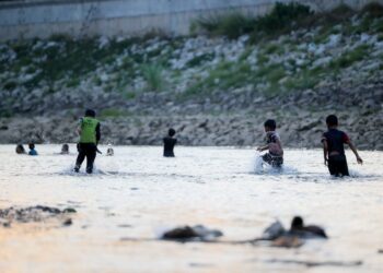 PENDUDUK mengambil kesempatan bermain dan mandi-manda selepas paras air Sungai Golok di Rantau Panjang, mulai cetek dan kering susulan cuaca panas melanda Kelantan ketika ini. - UTUSAN/KAMARUL BISMI KAMARUZAMAN