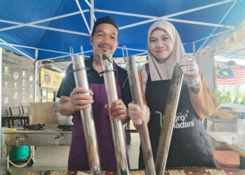 CHE Rimi Hussin (kiri) dan Norakhadah  menunjukkan lemang dimasak menggunakan ‘buluh besi’ di Kampung Nyior Tujuh, Besut, Terengganu.