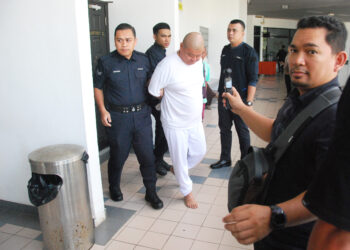 CHAI Koh Chun diiringi polis dibawa keluar dari Mahkamah Majistret Ayer Keroh hari ini. UTUSAN/AMRAN MULUP
HABIS